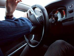 Médico de accidentes automovilísticos: interior del automóvil con la mano del conductor en el volante